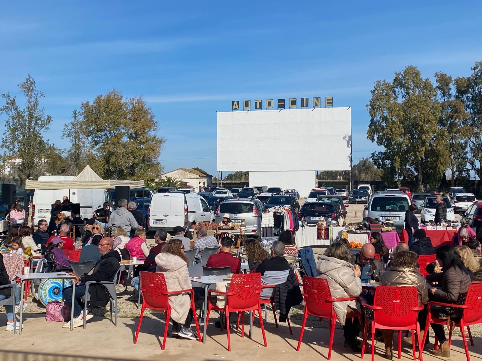 Sunday market stalls and café seating at Dénia Auto-Cine