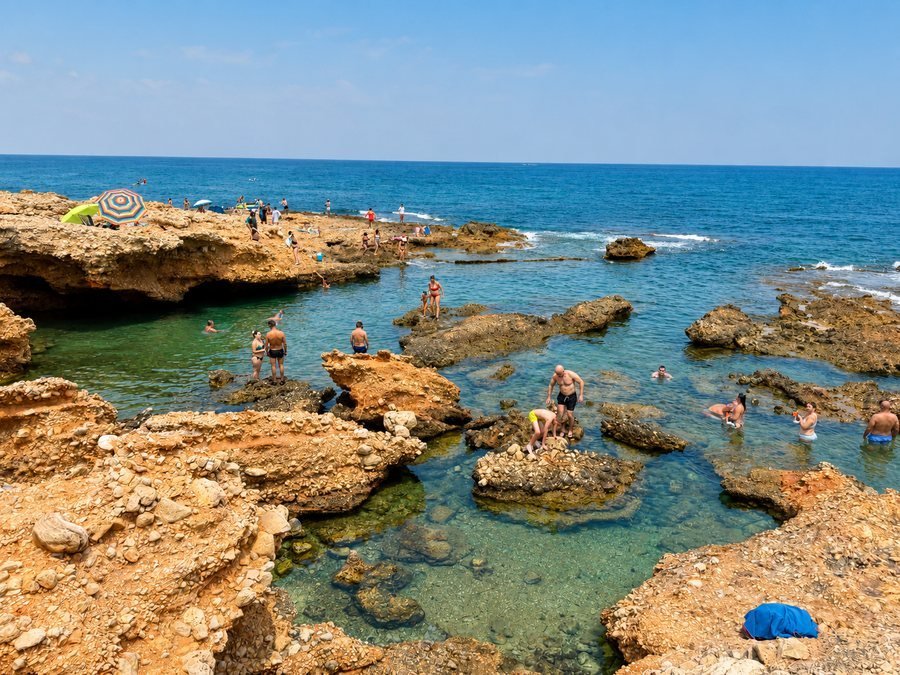 Rocky Les Rotes coast with clear water for exploring in Dénia